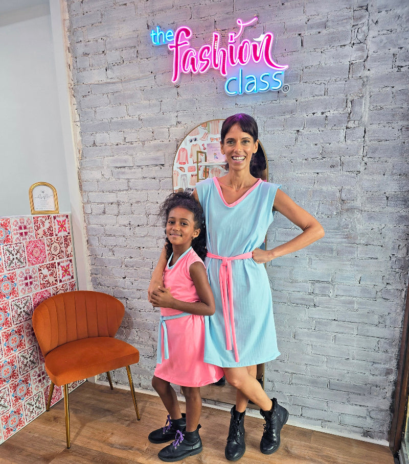 Mother daughter wearing self made dresses in front of a store sign