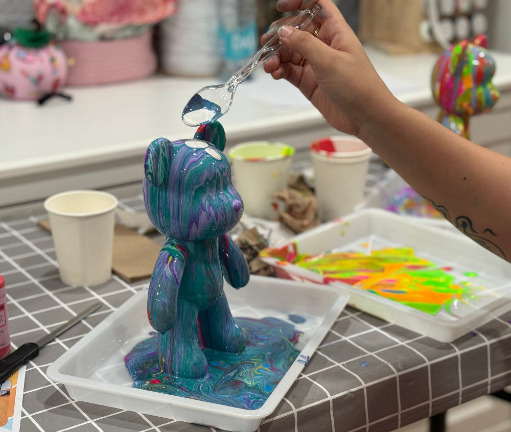 Person working on a blue and purple art project on a tiled countertop.